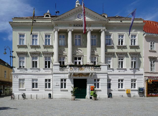 Das Rathaus der Stadt Baden am Hauptplatz mit Säulenportal und Fahnen